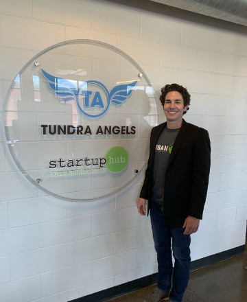 Tundra Angels manager Matthew Kee next to Tundra Angels and Startup Hub sign